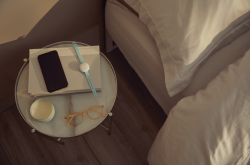 An Ava bracelet and smartphone on a bedside table. Image: COVID-RED project